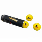Three yellow Adoral Cruise cricket tennis balls spilling out from black packaging tube