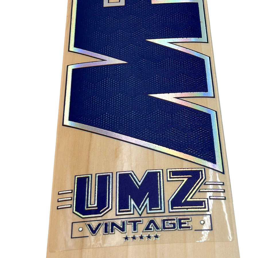 The full blade of the MB Malik 5 Star cricket bat resting on a grass pitch, showcasing its classic retro shape and heritage craftsmanship.