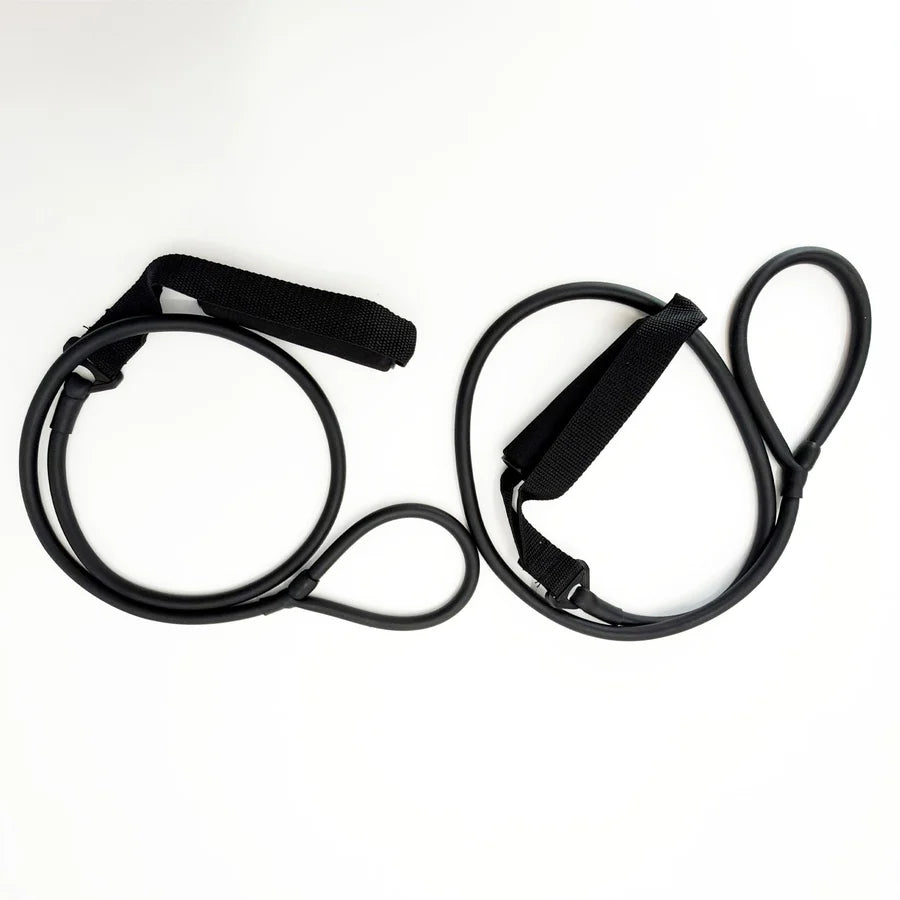 Full view of two black resistance stretching bands coiled with foam handles on white background
